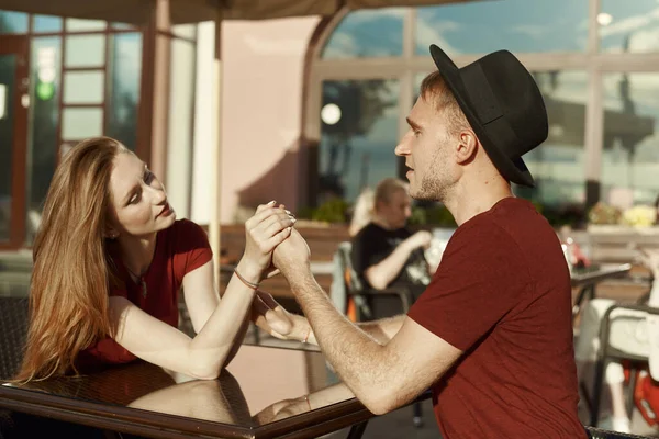 屋外カフェでの夏のデート。恋人たちは手を取り合って目を見る ストック写真
