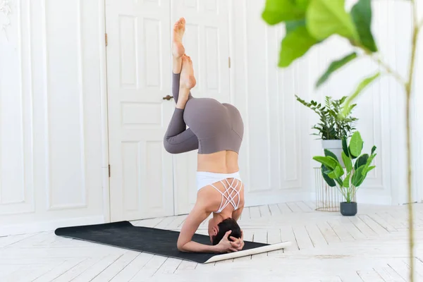 Kvinnlig yogalärare praktiserar i studio. Kvinna som gör en handstand — Stockfoto