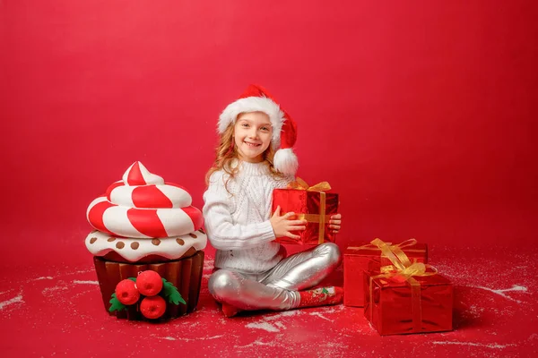 Niña Sombrero Santa Sobre Fondo Rojo Con Una Magdalena Regalos — Foto de Stock