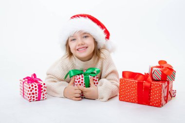 Noel Baba şapkalı şirin bir çocuk. Beyaz arka planda kutular dolusu hediyeler var.