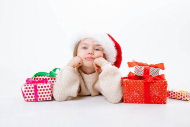 Noel Baba şapkalı şirin bir çocuk. Beyaz arka planda kutular dolusu hediyeler var.