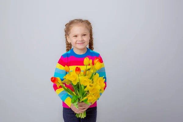 Cute Little Girl Multicolored Sweater Holds Bouquet Spring Flowers White — Stockfoto
