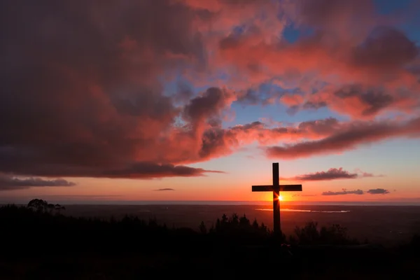 Croce del tramonto in cima alla collina — Foto Stock