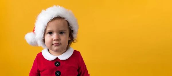 Banner Retrato bonito feliz alegre gordinha bebê menina em Santa terno olhando para a câmera no fundo amarelo. Criança Jogar Cena de Natal Celebrando Aniversário. Kid Divirta-se Passe o Ano Novo Espaço Copiar — Fotografia de Stock