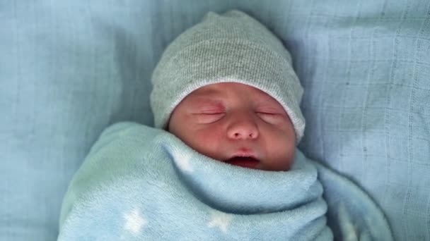 Retrato de la cara del bebé recién nacido Irritaciones alérgicas al acné Primeros días durmiendo sobre fondo azul. Niño al principio Minutos de la vida en sombrero. Bebés, Parto, Primeros Momentos Del Nacimiento, Principio Concepto — Vídeos de Stock