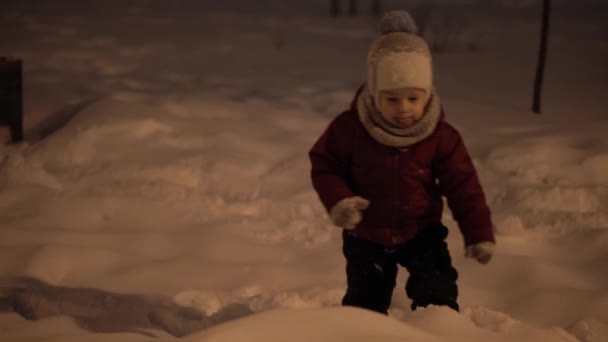 Invierno, vacaciones, juegos, conceptos familiares: plan intermedio de auténticos niños pequeños preescolares felices Los niños se divierten en el parque nocturno, esculpiendo bolas de nieve caen en la zona de nieve en clima frío y helado — Vídeo de stock