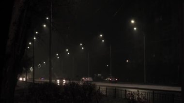 Hava tahmini, anomali, acil durum, element, kış konsepti - dengesiz bir kar fırtınası. Gece yolundaki sokak lambasının ışığında kar taneleri düşüyor. Kiev 'deki ilk kar