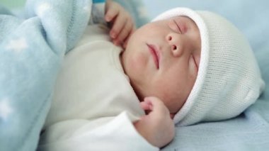 Yeni doğan bebek yüz portresinin yakın plan çekimleri. İlk günler beyaz mavi arka planda tatlı tatlı uyuyor. Hayata Başlayan Çocuk Şapka 'da. Bebekler, Doğum, Doğumun İlk Anları, Başlangıç Konsepti