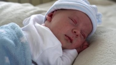 Yeni doğan bebek yüzü portresi İlk Günler Uyurken Tatlı Gülümseyen Beyaz Rüya Arkaplanı. Hayata Başlayan Çocuk Şapka 'da. Bebekler, Doğum, Doğumun İlk Anları, Başlangıç Konsepti