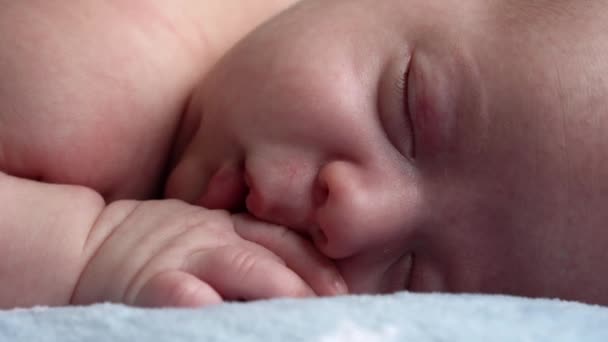 Βρεφική ηλικία, παιδική ηλικία, ανάπτυξη, ιατρική και υγεία, αγάπη, φροντίδα έννοια - close-up πρόσωπο του νεογέννητου γυμνό ύπνο μικρό αγοράκι βρέφος ξαπλωμένο στο στομάχι σε μαλακό μπλε κουκέτα στο κρεβάτι στο σπίτι — Αρχείο Βίντεο