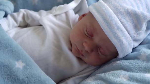 Plano Médio de Retrato de Rosto de Bebê Recém-Nascido Primeiros Dias em Macro Dormindo Sobre Fundo Estrela Azul. Criança no início minutos de vida no chapéu. Bebês, Parto, Primeiros Momentos de Borning, Princípio de Início — Vídeo de Stock