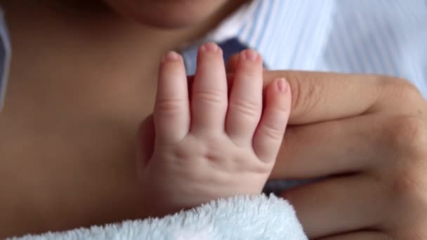 母性、子供時代、家族、ケア、健康、医学、皮膚科、妊産婦の概念。母親は幼い新生児の小さな手の指を撫でキスを保持しています.柔らかい乾燥した赤ちゃんの肌のクローズアップ — ストック動画