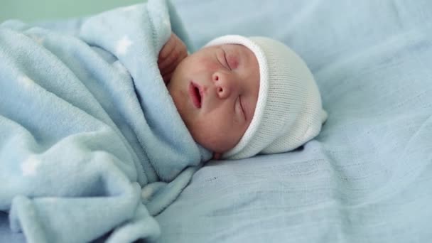 Newborn Baby Face Portrait Acne Allergic Irritations Early Days Sleeping On Blue Background. Child At Start Minutes Of Life on Hat. Infants, Childbirth, First Moments Of Borning, Beginning Concept — Stock Video