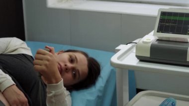Tıbbi kontrol kardiyografisi sırasında hastanede yatan hamile bir kadın. Hamilelik danışmanı olarak klinikteki jinekoloğu ziyaret et. Muayene Bekleyen Göbek Bebek Anne Sağlık Bakımı