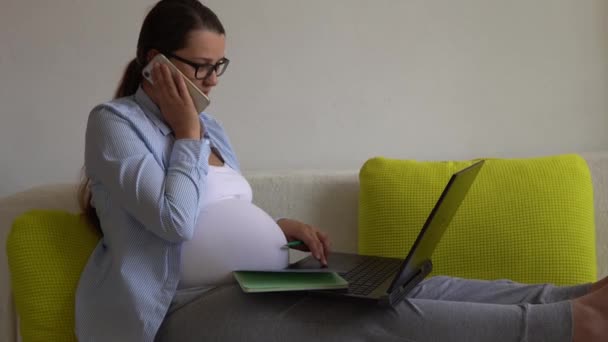 Femme d'affaires enceinte qui travaille dur avec succès avec ordinateur portable. Young Ledy In Pregnancy parle appel par téléphone Documents de travail Utilisation à distance d'Internet et de la technologie en ligne à la maison. Congé de maternité Concept — Video
