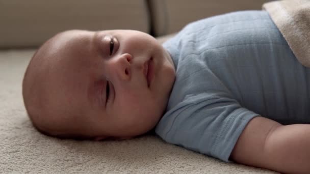 Close-up Side View Grappig schattig kind 2 maand pasgeboren jongen vallen in slaap na bad douche op wit zacht bed. Baby Child Waking Time voor het slapengaan Copy Space. Jeugd, Moederschap, Familie, Baby Concept — Stockvideo