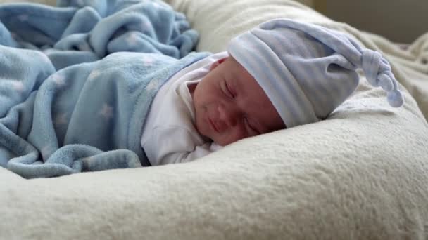 Retrato de la cara del bebé recién nacido Primeros días durmiendo dulcemente sonriendo a través del fondo blanco del sueño. Niño al principio Minutos de la vida en sombrero. Bebés, Parto, Primeros Momentos Del Nacimiento, Principio Concepto — Vídeos de Stock