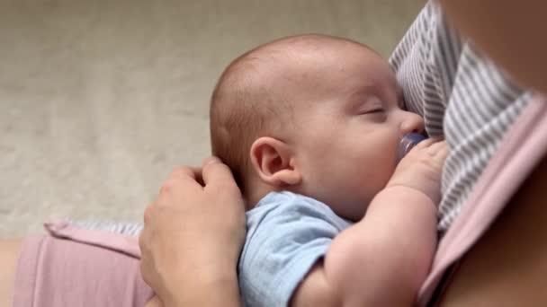 Annelik, çocukluk, aile, bakım, sağlık, annelik - emzik ile yakın çekim anne göğüs elleri üzerinde uyuyor. Anne rahatla, kucağına al. Bebek bebek yatakta. — Stok video