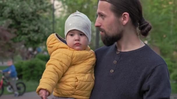 Pessoas no parque. pai segurar bebê filha menina nos braços e cócegas têm passar o tempo. pais e crianças divertidas andando ao ar livre ao ar livre. Dia dos pais, família feliz, infância, conceito de paternidade — Vídeo de Stock