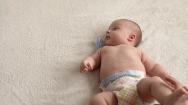 Cilt bakımı, gelişim pediyatrisi, bebek yakın çekim anne elleri kollara, bacaklara, parmaklara, ayak egzersizlerinde reflekslere, evde yatakta cilt göğsüne masaj yapar.