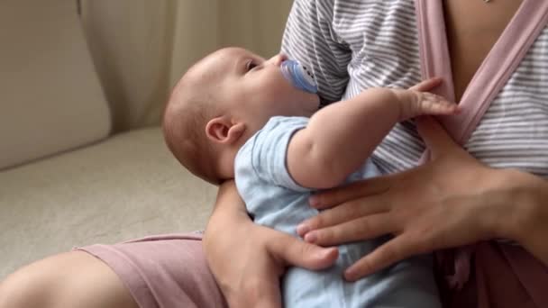 Keibuan, masa kecil, keluarga, perawatan, kesehatan, persalinan - bayi yang baru lahir dengan dot pakaian biru tidur di lengan ibu. Mum santai memegang memeluk bayi bayi bayi bayi di tempat tidur di rumah — Stok Video