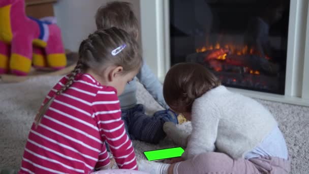 Schattige Vrolijke Gelukkige Slimme Vreugdevolle Peuter Kinderen Op Tapijt Met behulp van Smartphone Green Screen Mobiele telefoon Hromakey Kijken Video 's Ontspannen Thuis Cartoons Speel Internet Games. Kinderen genieten van leren — Stockvideo