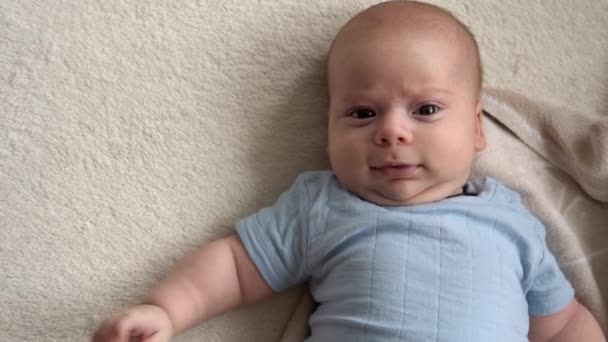 Close-up Top View Leuke jongen 2 maanden pasgeboren jongen op zoek naar camera na bad douche op wit zacht bed. Baby Child Waking Time voor het slapengaan Copy Space. Jeugd, Moederschap, Familie, Baby Concept — Stockvideo