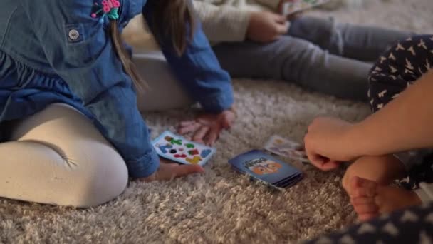 Gyerekkor, oktatás, hobbi, család, barátok, barátság koncepció. Boldog fiatal anya anya bébiszitter kis óvodás gyerekek gyerekek időt játszanak kártyajáték otthon kandalló — Stock videók