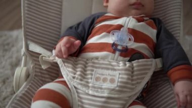 Kameradaki bebeğe bakmak, çocukluk, aile sevgisi. Çizgili elbiseli şirin gülen yüz uyandı. Evdeki şöminenin yanındaki sandalyeye uzandı. Neşeli yaşam tarzı mutlu çocuk.