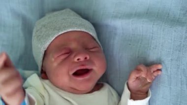 Mavi Arkaplanda Ağlayan Macro 'daki Tatlı Yeni Doğan Bebek Kırmızı Yüz Portresi' nin yakın çekimi. Hayata Başlayan Çocuk Şapka 'da. Bebekler, Doğum, Doğumun İlk Anları, Başlangıç Konsepti