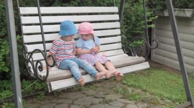 Garden Swing Bench 'teki Mutlu Çocuklar Sabun Baloncukları. Oğlan ve Kız Çocuk, Güneşli Yaz Günü 'nde Idyllic Banliyö Evi' nin arka bahçesinde oyun oynuyorlar. Çocukluk, aile kavramı