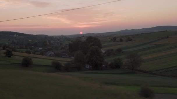 夏の背景には夕暮れ時の空の日没時に自然畑や森の風景の上の窓高速列車からの眺め。地平線に赤い夕日。交通、旅行、鉄道、通信の概念 — ストック動画