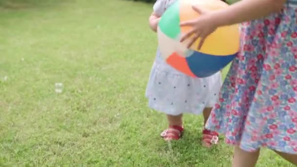 Happy Children runing with Multi-Color Beach Ball and Soap Bubbles. Mother, Daughter and Son Have Fun Playing Games in Backyard Lawn of Idyllic Suburban House on Summer Day. Childhood, family concept — Stock Video