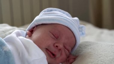 Yakın plan Yeni Doğmuş Bebek Yüzü İlk Günler Mavi Göbek Arkaplanında Tatlı Uyuyan Bebek Portresi. Hayata Başlayan Çocuk Şapka 'da. Bebekler, Doğum, Doğumun İlk Anları, Başlangıç Konsepti