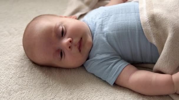 Closeup Side View Funny Cute Kid 2 Month Newborn Boy Falling Asleep After Bath Shower On White Soft Bed Дитяча дитина прокидається до часу після закінчення робочого дня копіювання простору. Дитинство, материнство, сім "я, ідея немовлят — стокове відео