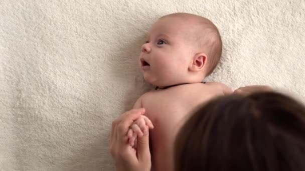 Auténtico primer plano disparo joven madre neo está jugando con el bebé recién nacido desnudo en la cama blanda blanca en el día de la mañana guardería. Concepto de hijos, paternidad, infancia, vida, maternidad, maternidad — Vídeos de Stock