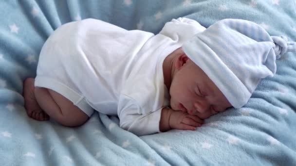 Yakın plan Yeni Doğmuş Bebek Yüzü İlk Günler Mavi Yıldızlı Arkaplanda Tatlı Uyuyor. Hayata Başlayan Çocuk Şapka 'da. Bebekler, Doğum, Doğumun İlk Anları, Başlangıç Konsepti — Stok video