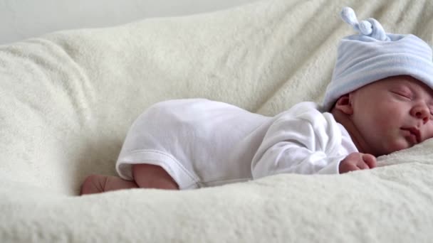 Nahaufnahme Newborn Face Portrait Early Days Schlafen süß auf Bauch Beige Weiß Hintergrund. Kind am Anfang Minuten des Lebens auf Hut. Säuglinge, Geburt, erste Momente der Langeweile, Konzeptbeginn — Stockvideo