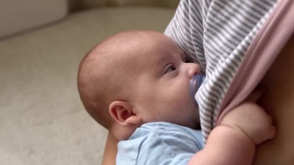Macierzyństwo, dzieciństwo, rodzina, opieka, zdrowie, macierzyństwo - zbliżenie noworodka smoczkiem w niebieskim body śpiącym na ramieniu matki. Mama relaks gospodarstwa pocałunek przytulić niemowlę dziecko na łóżku w domu — Wideo stockowe
