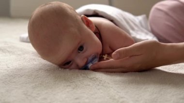 Cilt bakımı, gelişim pediyatrisi, bebek yakın çekim anne elleri kollara, bacaklara, parmaklara, ayak egzersizlerinde reflekslere, evde yatakta cilt göğsüne masaj yapar.