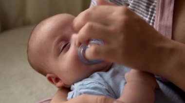 annelik, çocukluk, aile, bakım, sağlık, annelik - emzik ile yakın çekim anne göğüs elleri üzerinde uyuyor. Anne rahatla, kucağına al. Bebek bebek yatakta.
