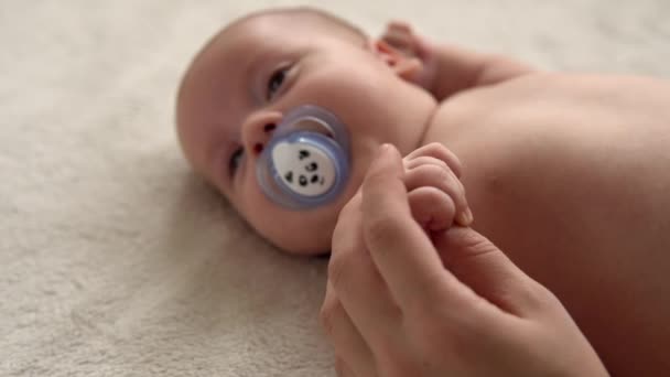 Saúde cuidados com a pele, pediatria desenvolvimento, bebê close-up mãe mãos dar nu recém-nascido bebê criança massagem nos braços, pernas, dedos, reflexo no exercício pés, esfregando pele abdômen peito na cama em casa — Vídeo de Stock