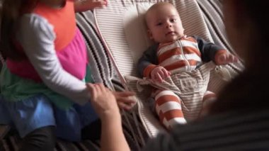 Omuz omuza. Çocukluk, annelik, aile. Çizgili pijamalı yeni doğmuş bebek uyanmış etrafa bakıyor gülümseyen oyunlar oynuyor annemi evde tanıdı.