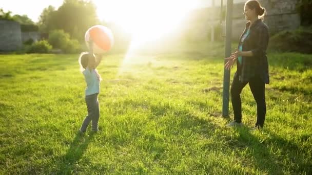 Лето, природа, счастливая семья, беременность, День матери - беременная мама с двумя малышами, играющими в игры с большим мячом в парке на закате. Счастливые улыбающиеся дети веселятся, смеются, проводят время вместе — стоковое видео