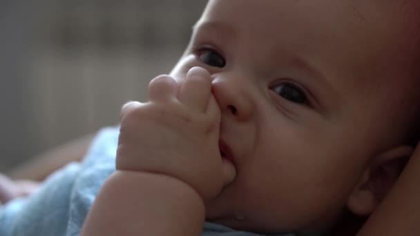 Close-up gezicht van pasgeboren baby in de vroege dagen Wakes Up Chews Fist Sticks Fingers In Mouth. Zuigelingenverdriet na de droom. Kind in de eerste minuten van het leven Portret in Macro. Jeugd, Jeugd Concept — Stockvideo