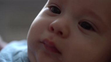 Yeni doğan bebeğin ilk günlerdeki şirin yüzü uyanır ve gözlerini açar. Bebek Çocuk Mavi Beden Giysisi İçinde Rüya Gördükten Sonra Somurtuyor. Makro 'daki İlk Dakika Çocuk Portresi. Çocukluk, Çocukluk Konsepti