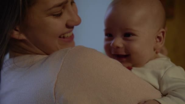 Autêntico tiro jovem neo mãe feliz está mantendo em braços e acariciando bebê recém-nascido sorridente Criança na noite em casa. Conceito maternidade, maternidade, paternidade, infância, vida, autenticidade — Vídeo de Stock