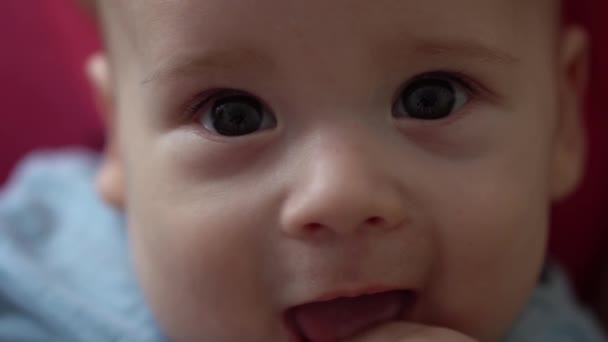 Gros plan Mignon sourire visage de nouveau-né dans les premiers jours se réveille bâtons doigt dans la bouche. Enfant en bas âge Grimaces After Dream. Enfant dans les premières minutes de la vie Portrait en macro. Enfance, concept de petite enfance — Video