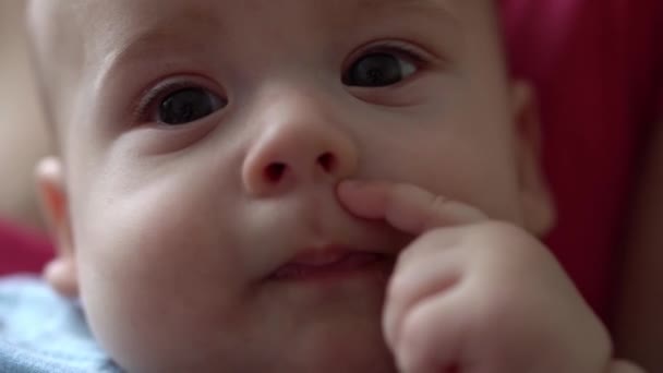 Close-up Gesicht des neugeborenen Babys in frühen Tagen wacht Kaugummis Faust Sticks Finger in den Mund Säuglingsgrimassen nach dem Traum. Kid In First Minutes Of Life Portrait In Macro. Kindheit, Kleinkindkonzept