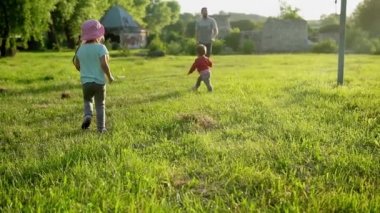 Yaz, tatil, doğa, mutlu aile, çocukluk, dostluk, evcil hayvan, hayvanlar - iki küçük çocuk anaokulu çocukları kardeş kardeş ikizler gün batımında çimenlerde köpek gezdirirken eğleniyorlar.